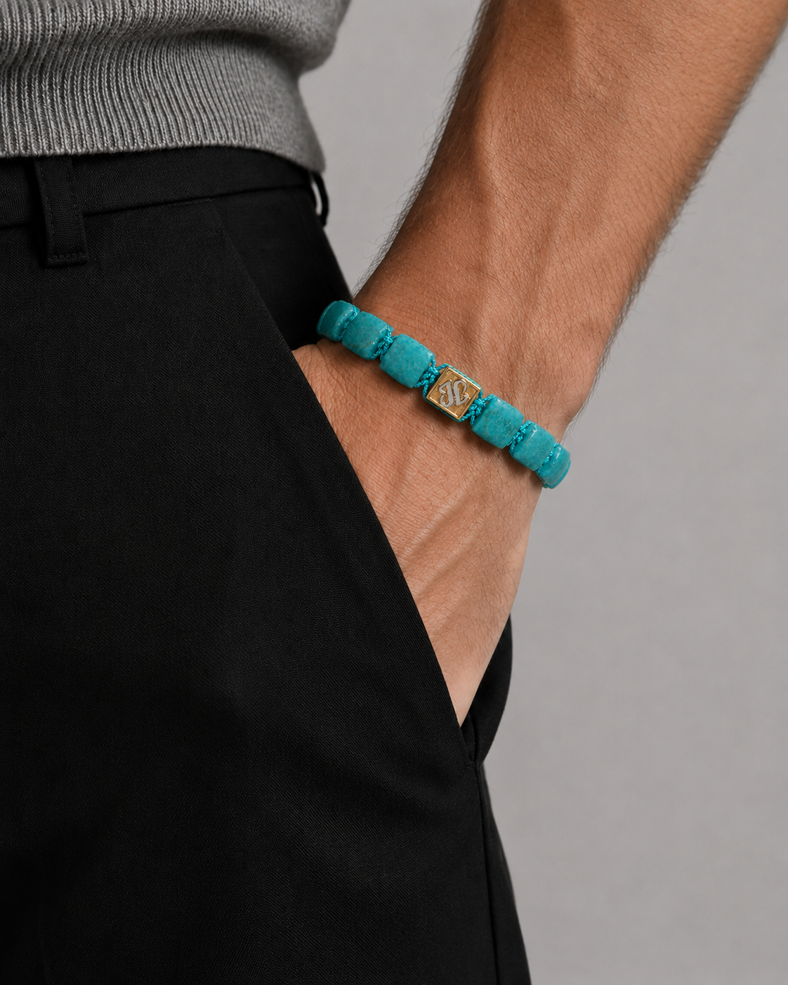 Turquoise bracelet on a person's wrist against a neutral background