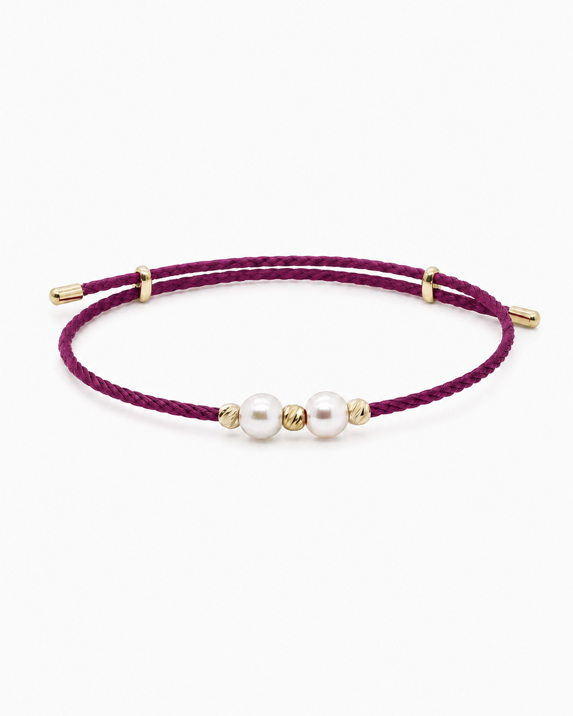 Bracelet with purple cord, gold beads, and white pearls on a white background #Color_
