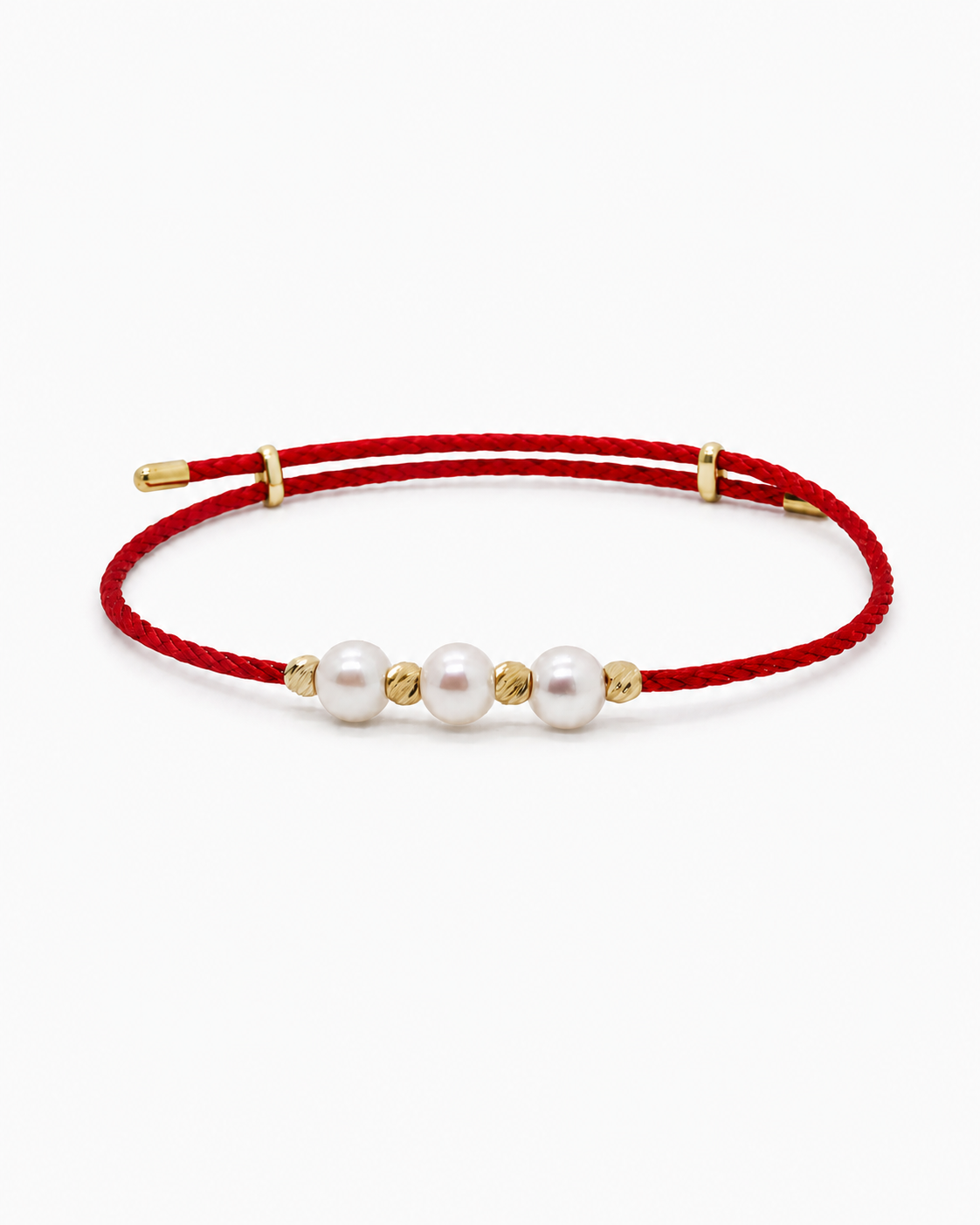 Red bracelet with pearls and gold accents on a white background