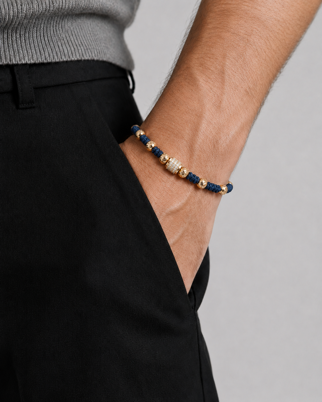 Bracelet with blue and gold beads on a wrist against a neutral background