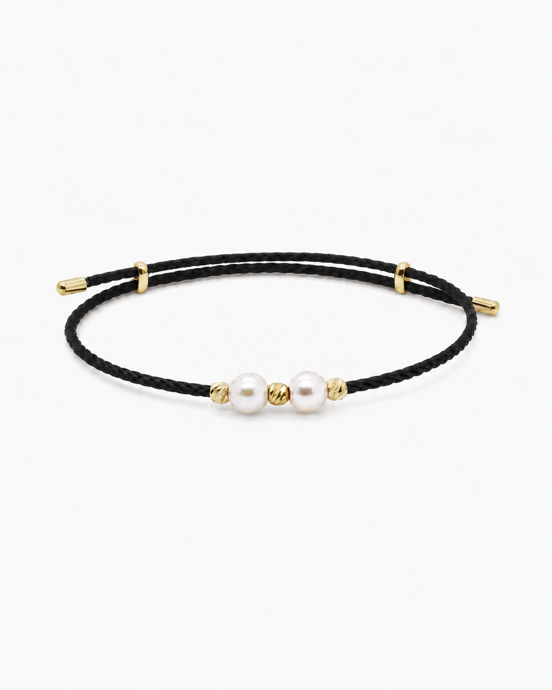 Black cord bracelet with gold accents and pearls on a white background