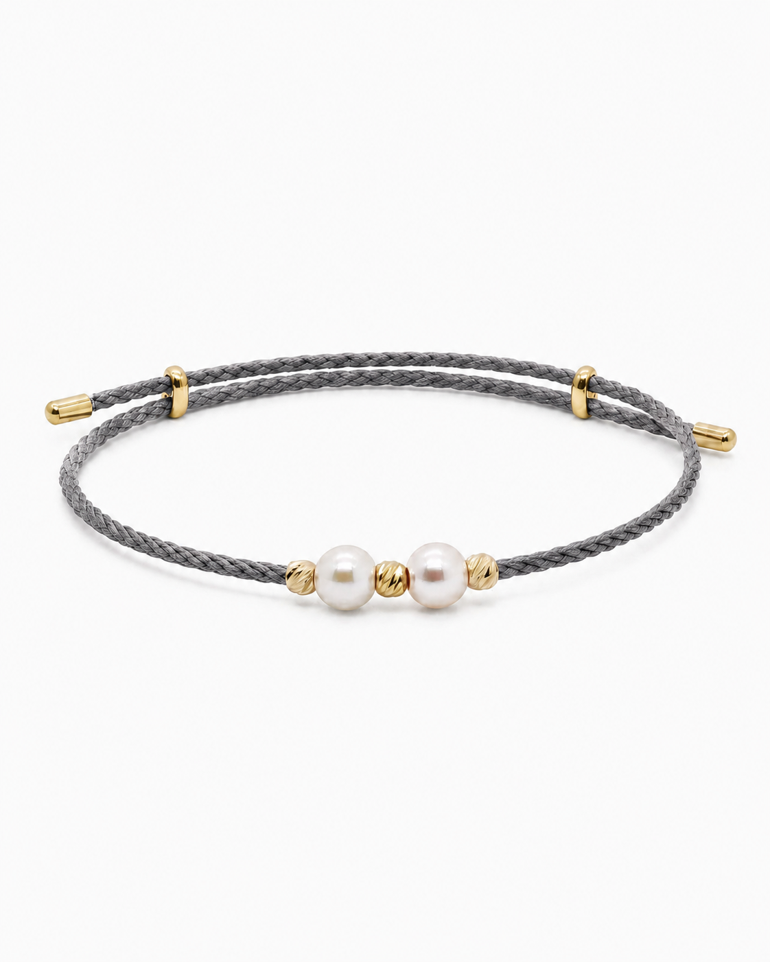 Bracelet with pearls and gold accents on a gray cord against a white background #Color_