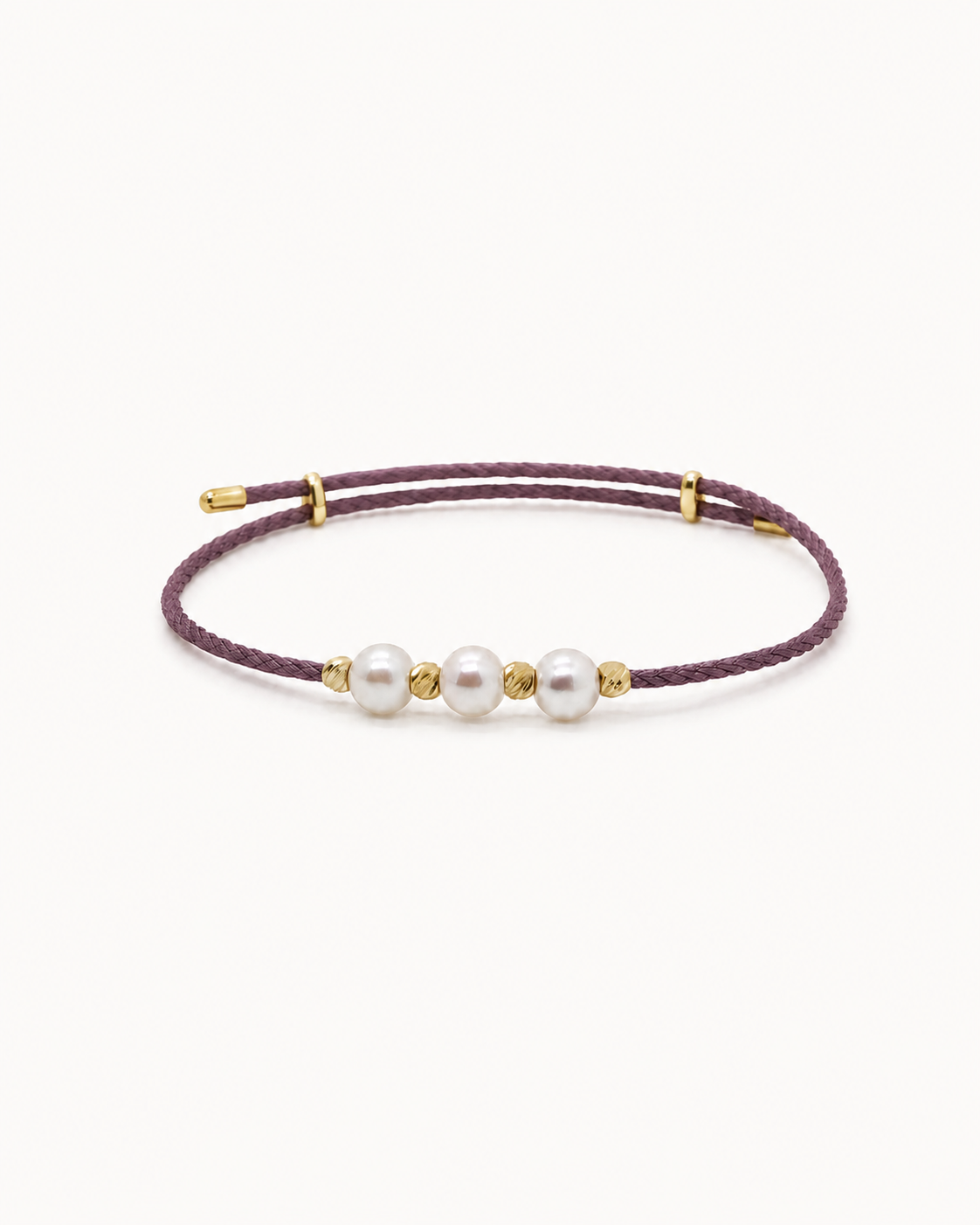 Bracelet with three pearls on a purple cord against a white background #Color_